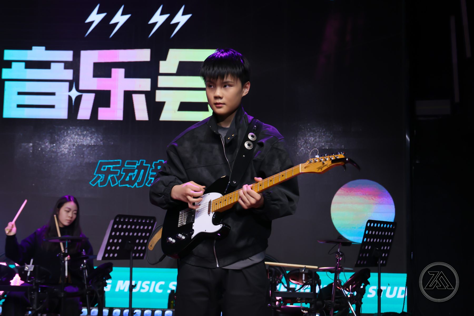Yixuan playing electric guitar in a live band performance